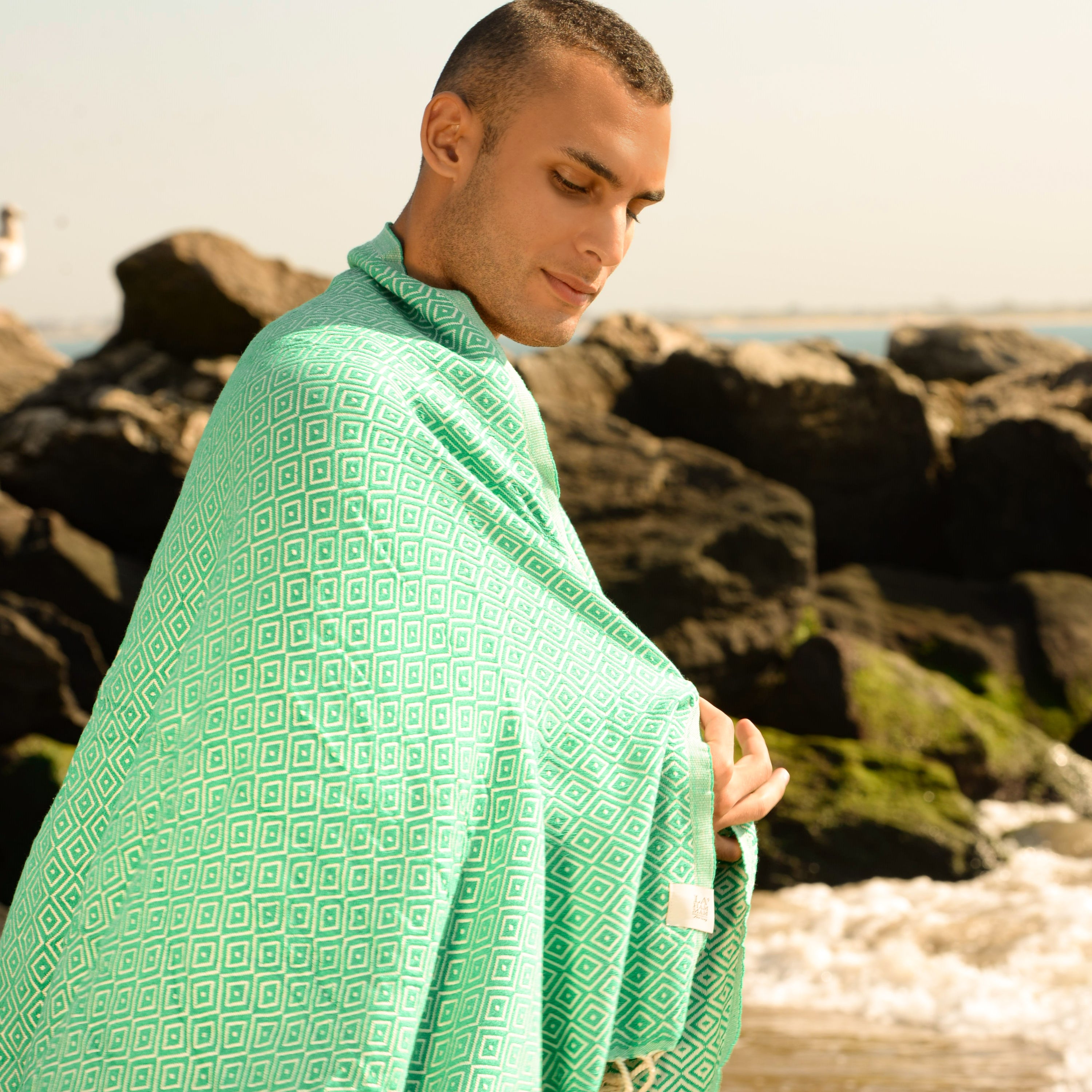 Malta Beach Towel displayed on a sandy beach, showcasing its vibrant colors and traditional woven design, perfect for beach and outdoor activities.