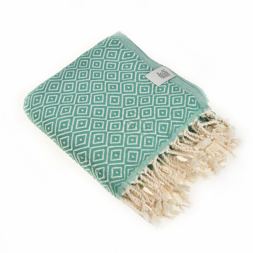 Malta Beach Towel displayed on a sandy beach, showcasing its vibrant colors and traditional woven design, perfect for beach and outdoor activities.