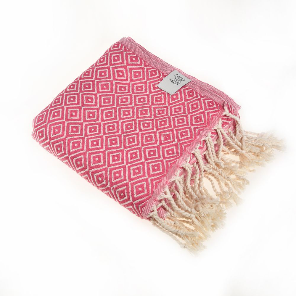 Malta Beach Towel displayed on a sandy beach, showcasing its vibrant colors and traditional woven design, perfect for beach and outdoor activities.