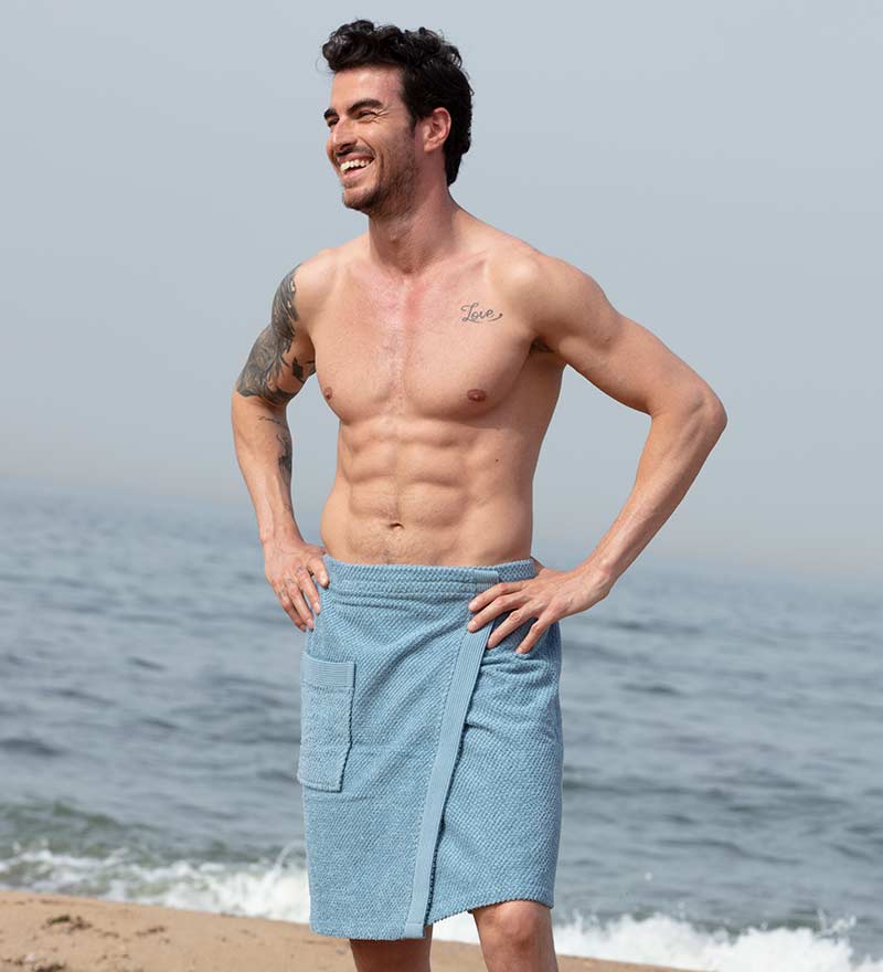 Men's Turkish Cotton Towel Wrap in various colors, showcasing its adjustable velcro closure and pocket feature.