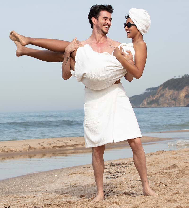 Men's Turkish Cotton Towel Wrap in various colors, showcasing its adjustable velcro closure and pocket feature.