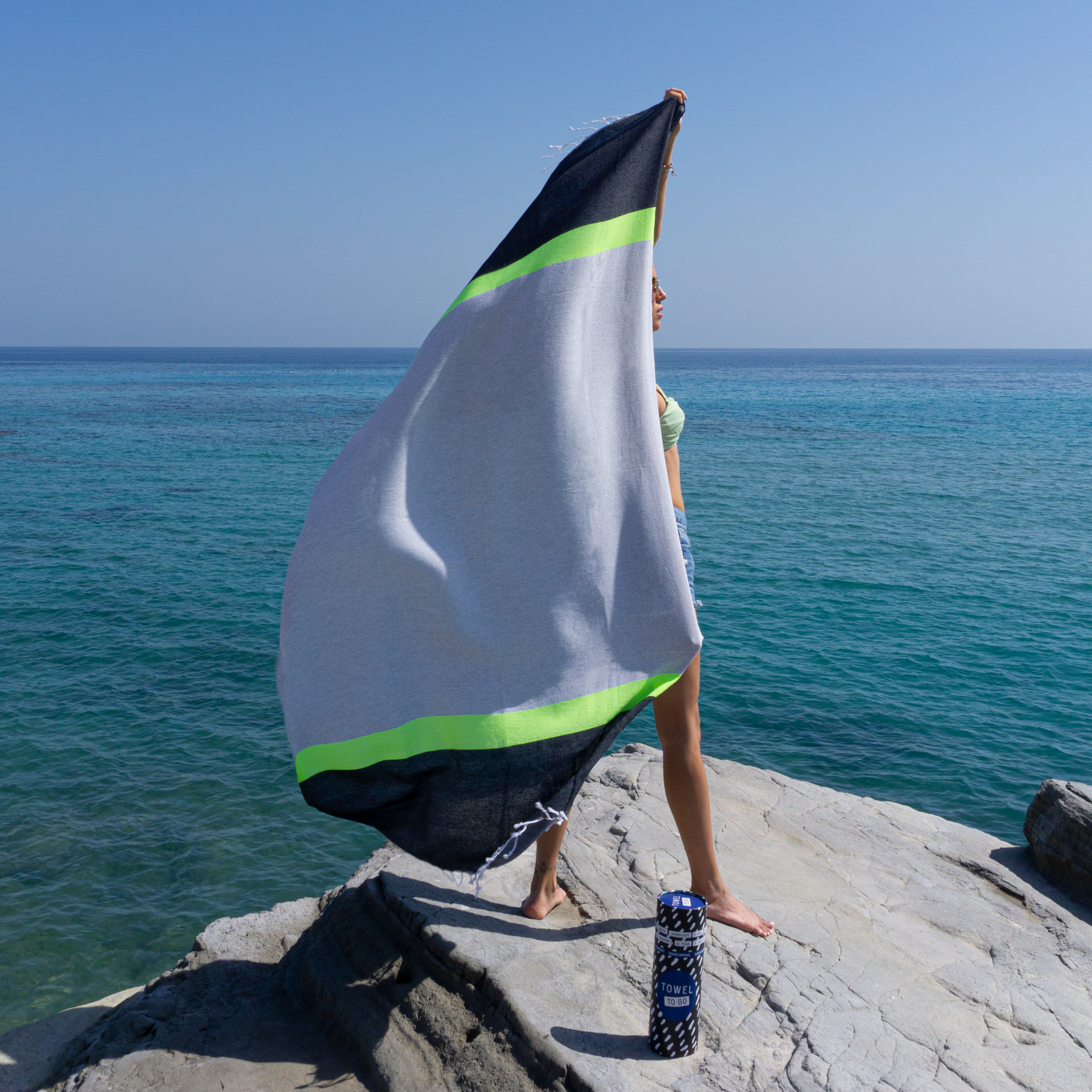 Neon Beach Towel in grey and black with neon stripe, displayed in a recycled gift box, showcasing eco-friendly design.