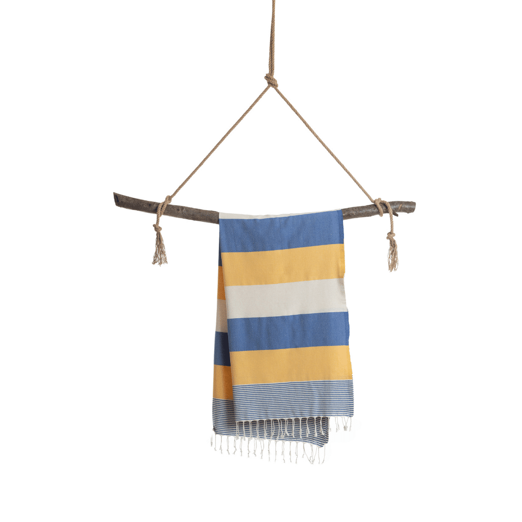 Palermo Beach Towel featuring vibrant blue and yellow stripes, handwoven from 100% cotton, displayed in a recycled gift box.