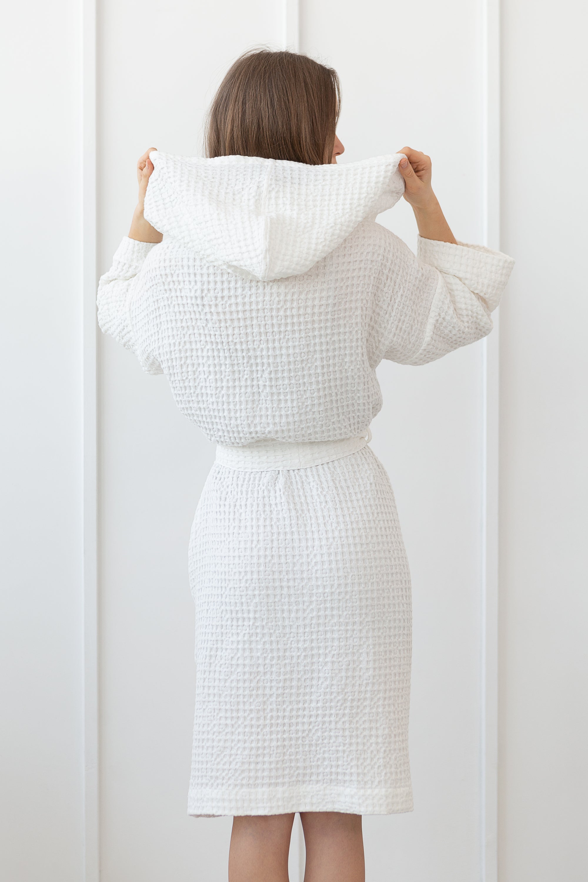 White linen waffle robe with a cozy hoodie, featuring a soft texture and two front pockets, perfect for relaxation.