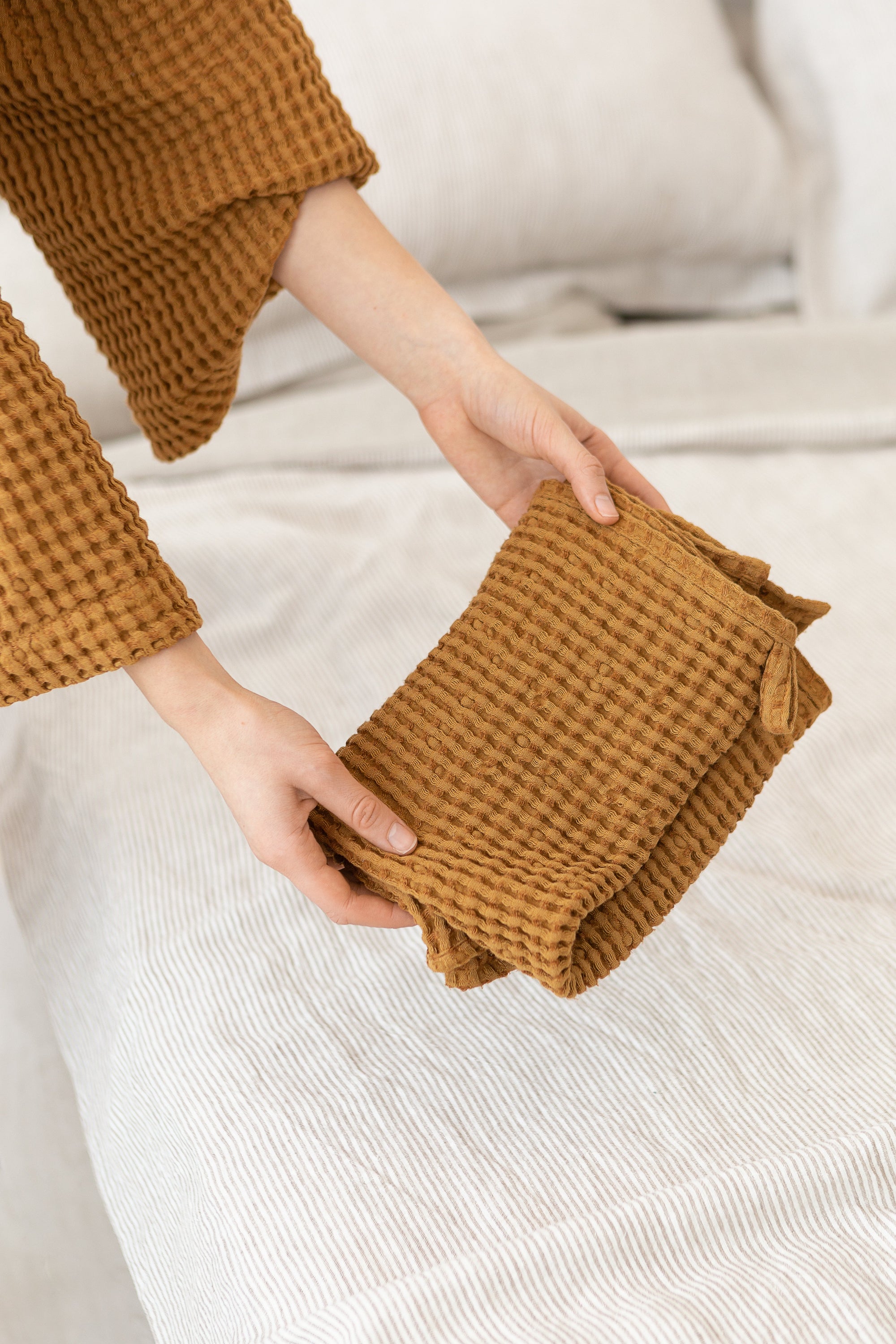 A set of white linen waffle towels featuring a stylish pattern, showcasing a hand towel and a bath towel, perfect for luxury drying.