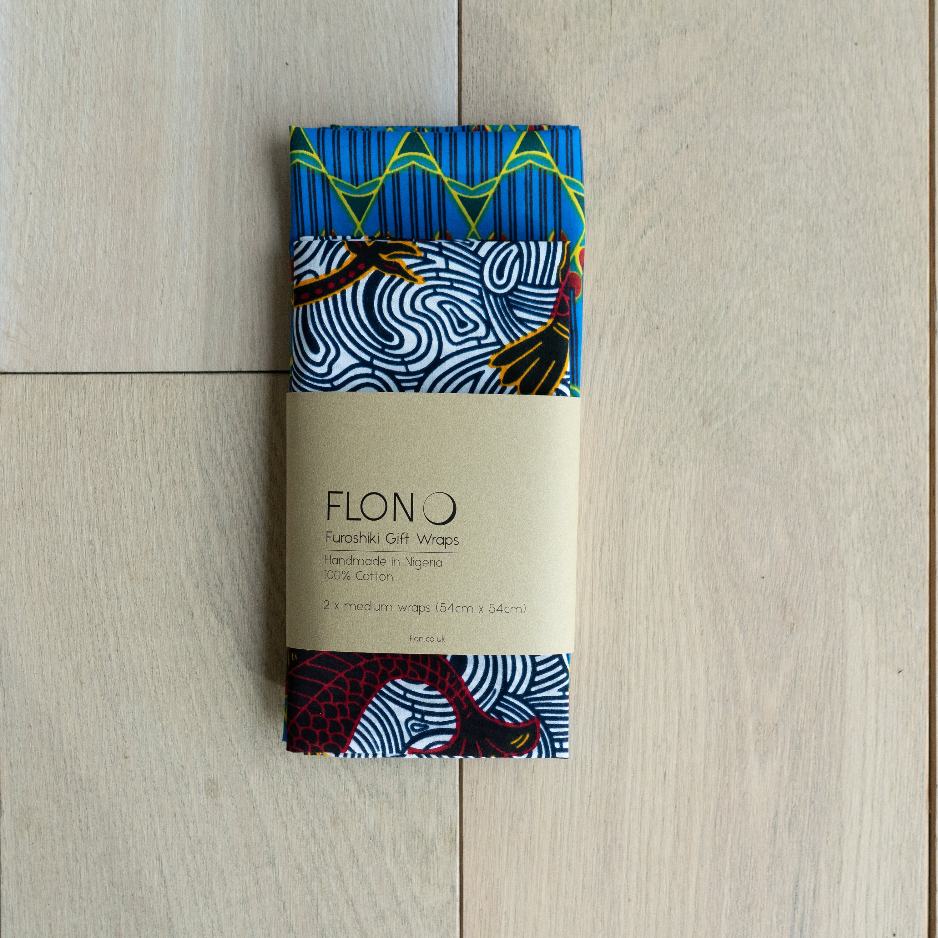 Two vibrant Furoshiki inspired Ankara Gift Wraps showcasing intricate patterns, perfect for eco-friendly gifting.