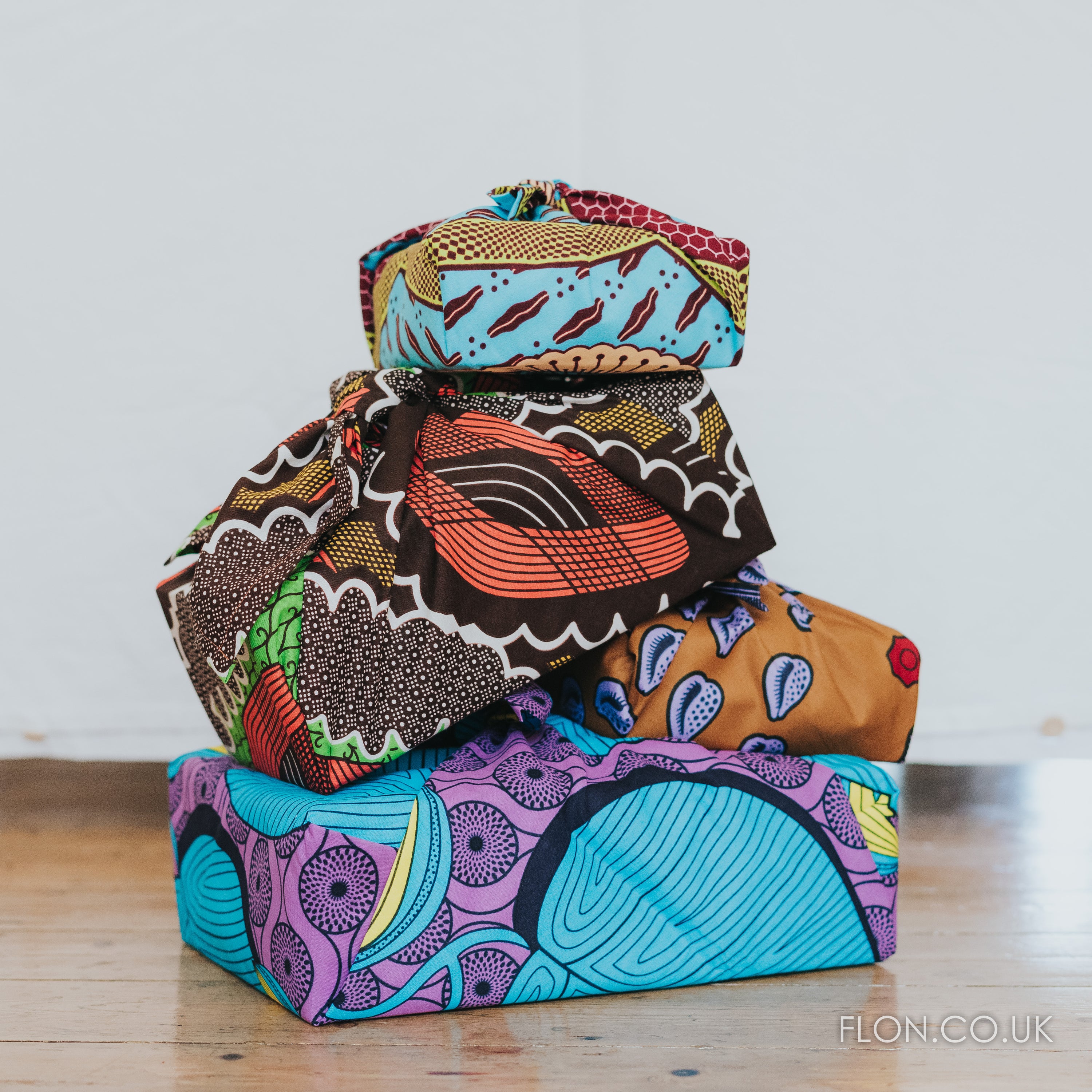 Two vibrant Furoshiki inspired Ankara Gift Wraps showcasing intricate patterns, perfect for eco-friendly gifting.