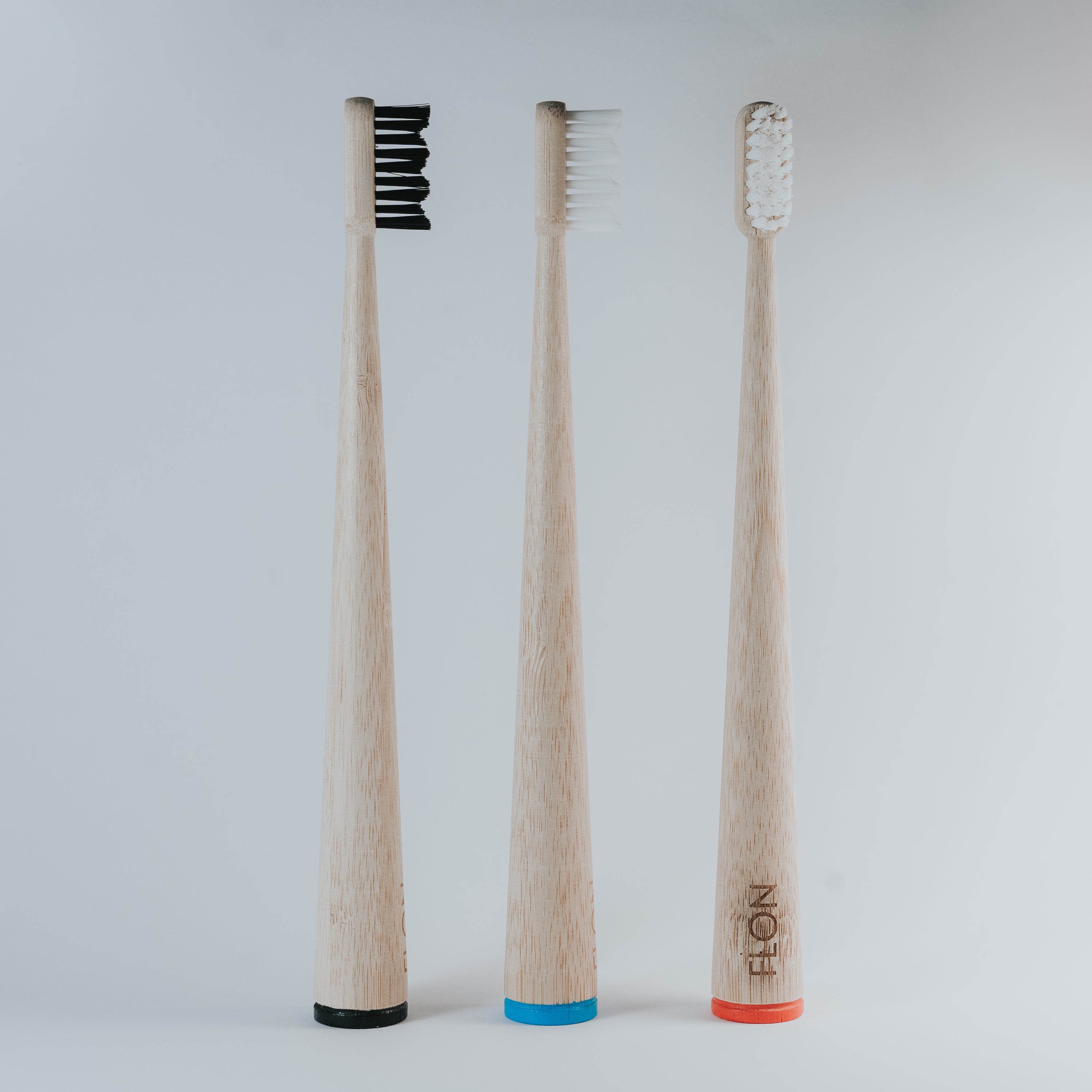 FLON Adult Bamboo Toothbrush with biodegradable bamboo handle and non-BPA bristles, showcasing eco-friendly design.