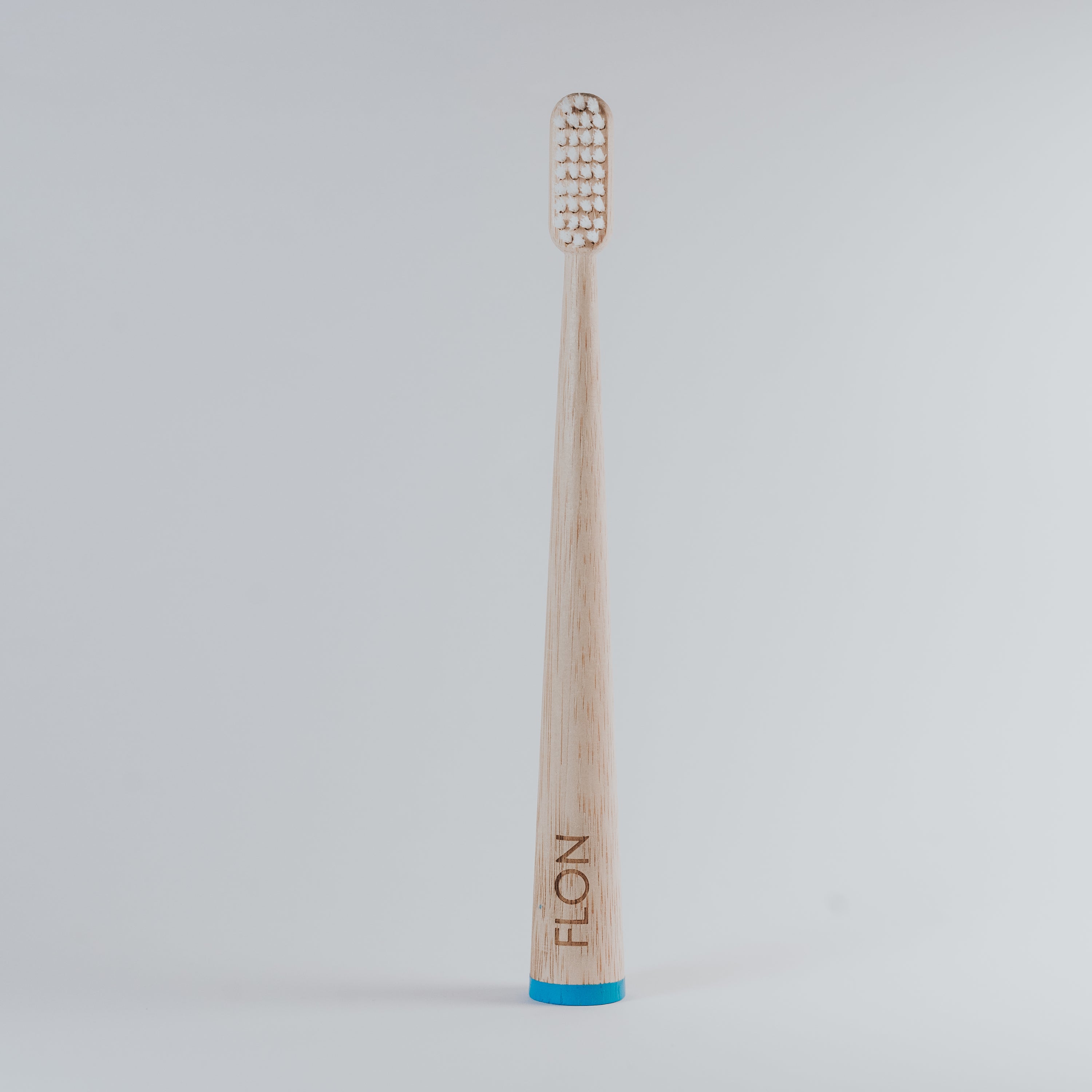 FLON Adult Bamboo Toothbrush with biodegradable bamboo handle and non-BPA bristles, showcasing eco-friendly design.