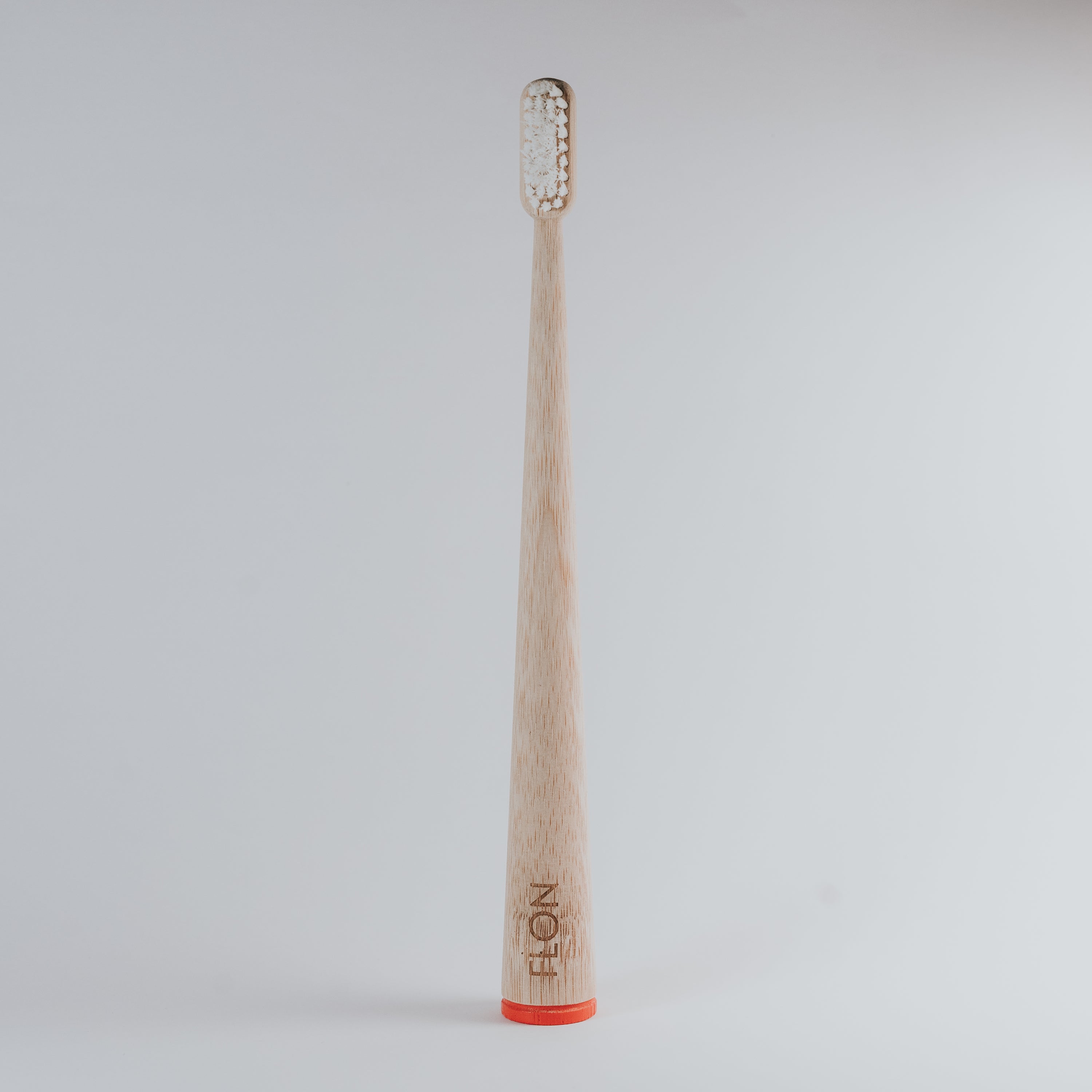 FLON Adult Bamboo Toothbrush with biodegradable bamboo handle and non-BPA bristles, showcasing eco-friendly design.