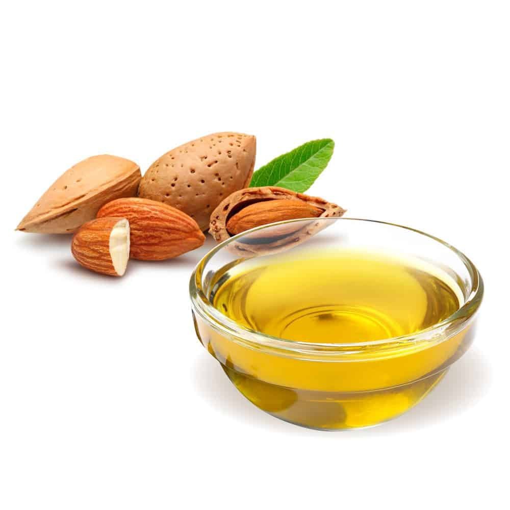 A bottle of almond oil with almonds scattered around, showcasing its natural beauty benefits.