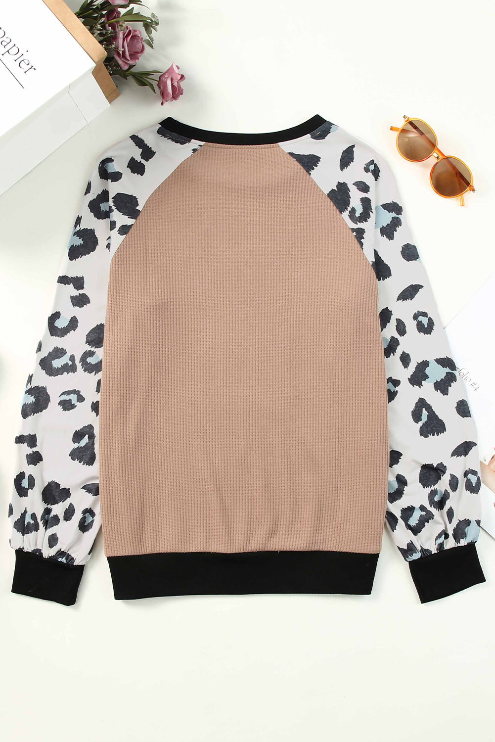 Apricot knitted pullover top with leopard print sleeves, showcasing a stylish and casual design.