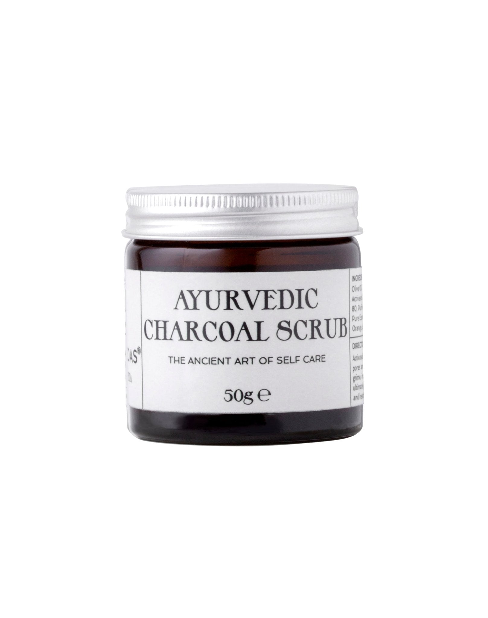 Ayurvedic Charcoal Scrub in a jar with natural ingredients around it, showcasing its organic and rejuvenating properties.