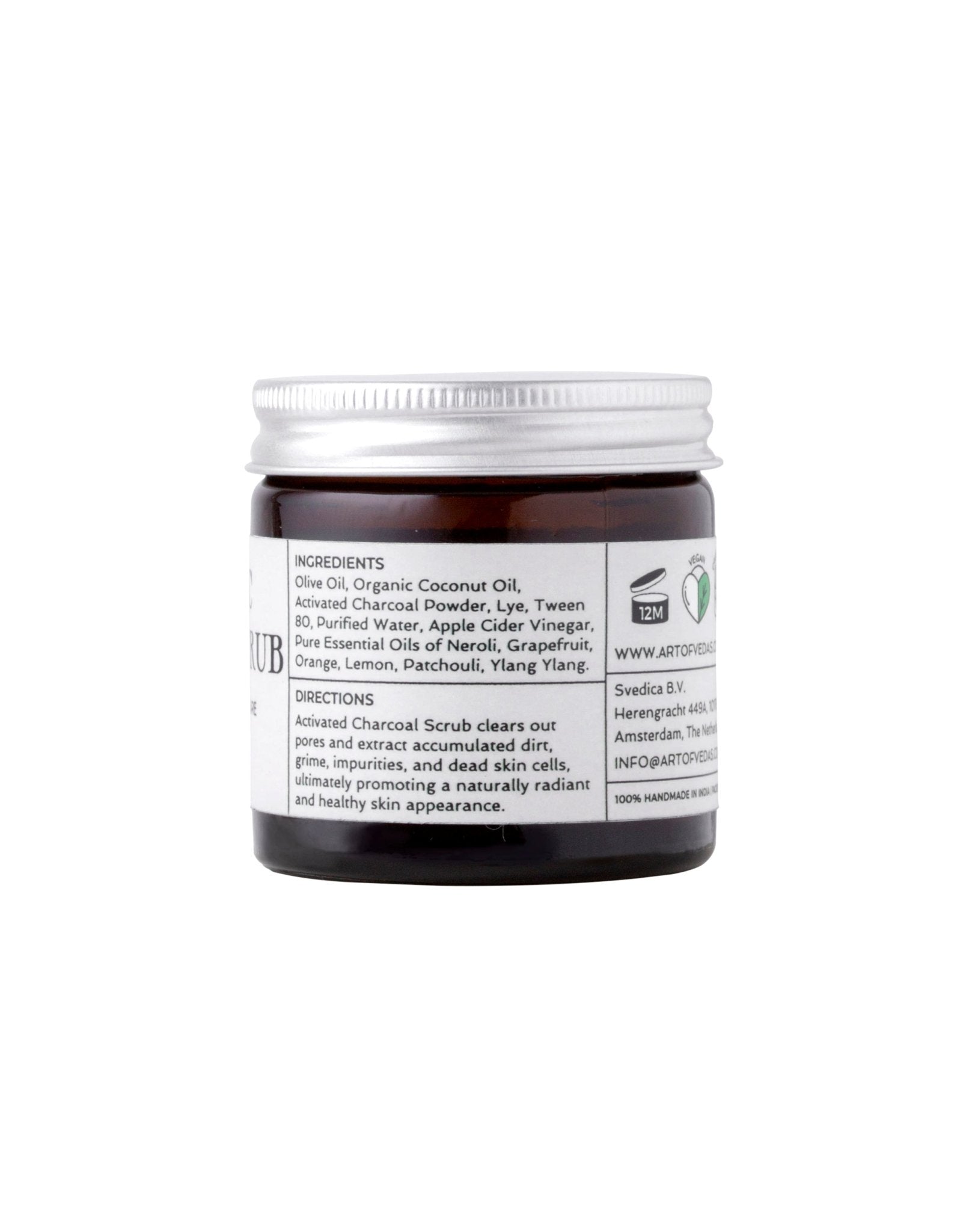 Ayurvedic Charcoal Scrub in a jar with natural ingredients around it, showcasing its organic and rejuvenating properties.