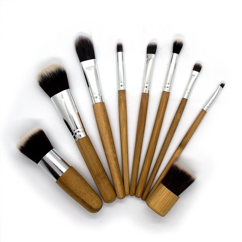 A set of 9 eco-friendly bamboo makeup brushes with soft synthetic bristles, showcasing their sustainable design and variety.