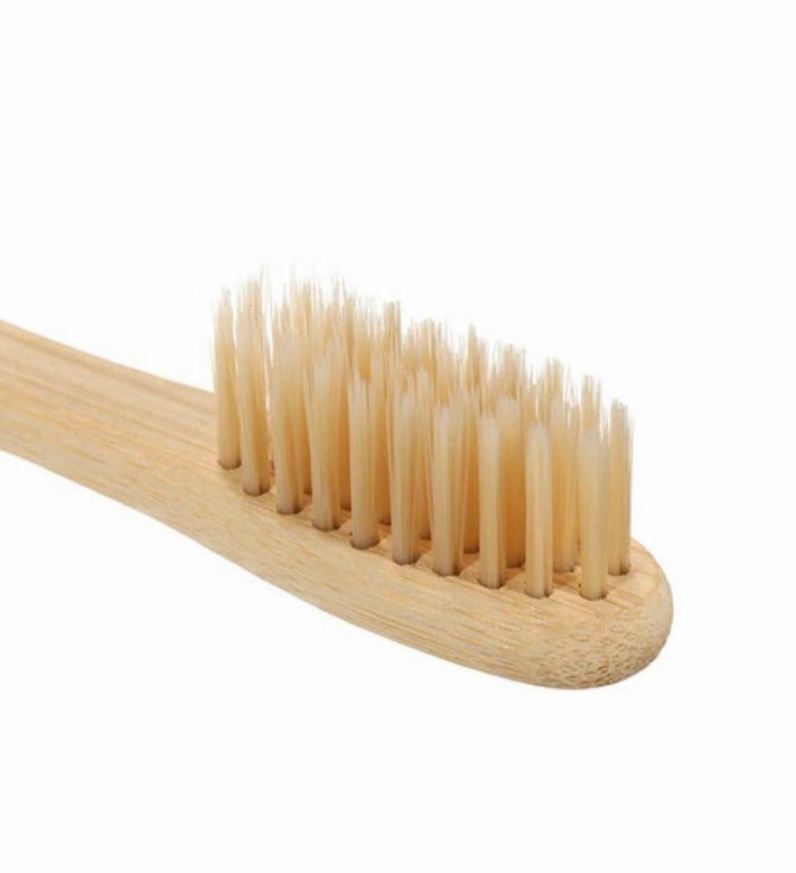 Eco-friendly bamboo toothbrush with soft nylon bristles, featuring a non-slip handle and a delicate design.