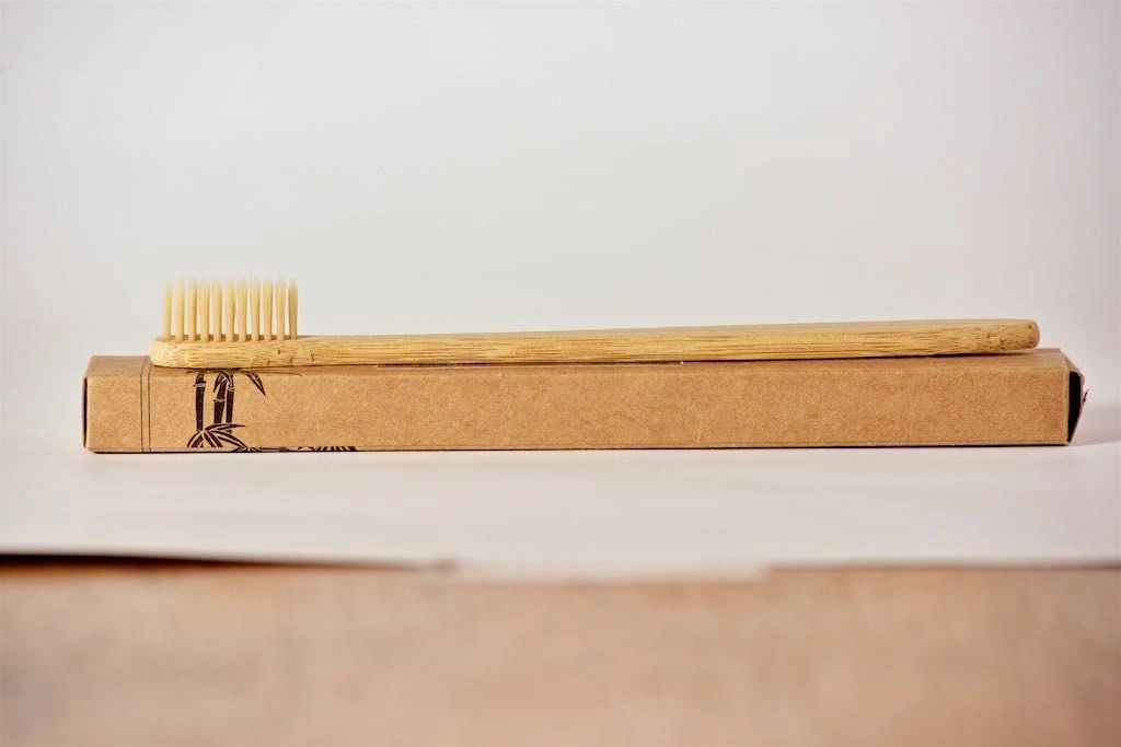 Eco-friendly bamboo toothbrush with soft nylon bristles, featuring a non-slip handle and a delicate design.