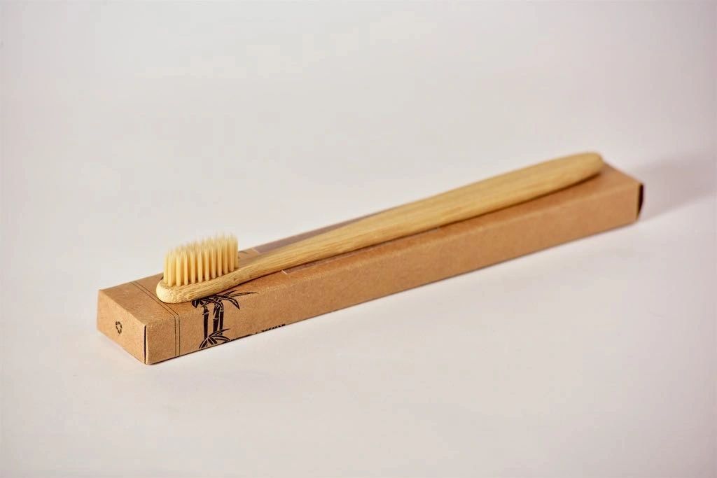 Eco-friendly bamboo toothbrush with soft nylon bristles, featuring a non-slip handle and a delicate design.