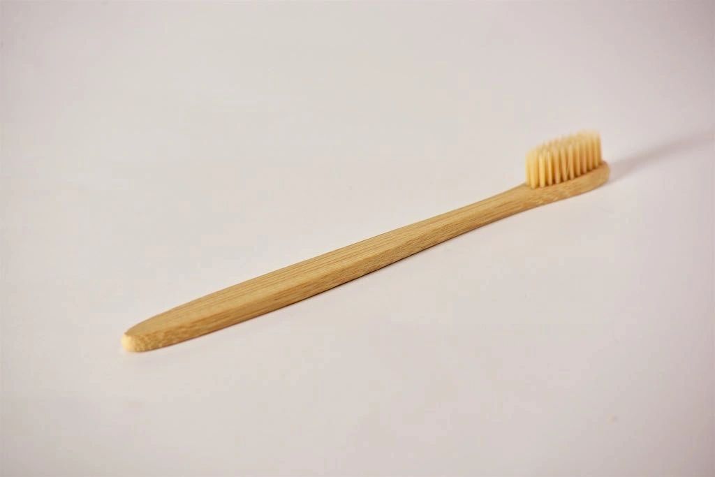 Eco-friendly bamboo toothbrush with soft nylon bristles, featuring a non-slip handle and a delicate design.