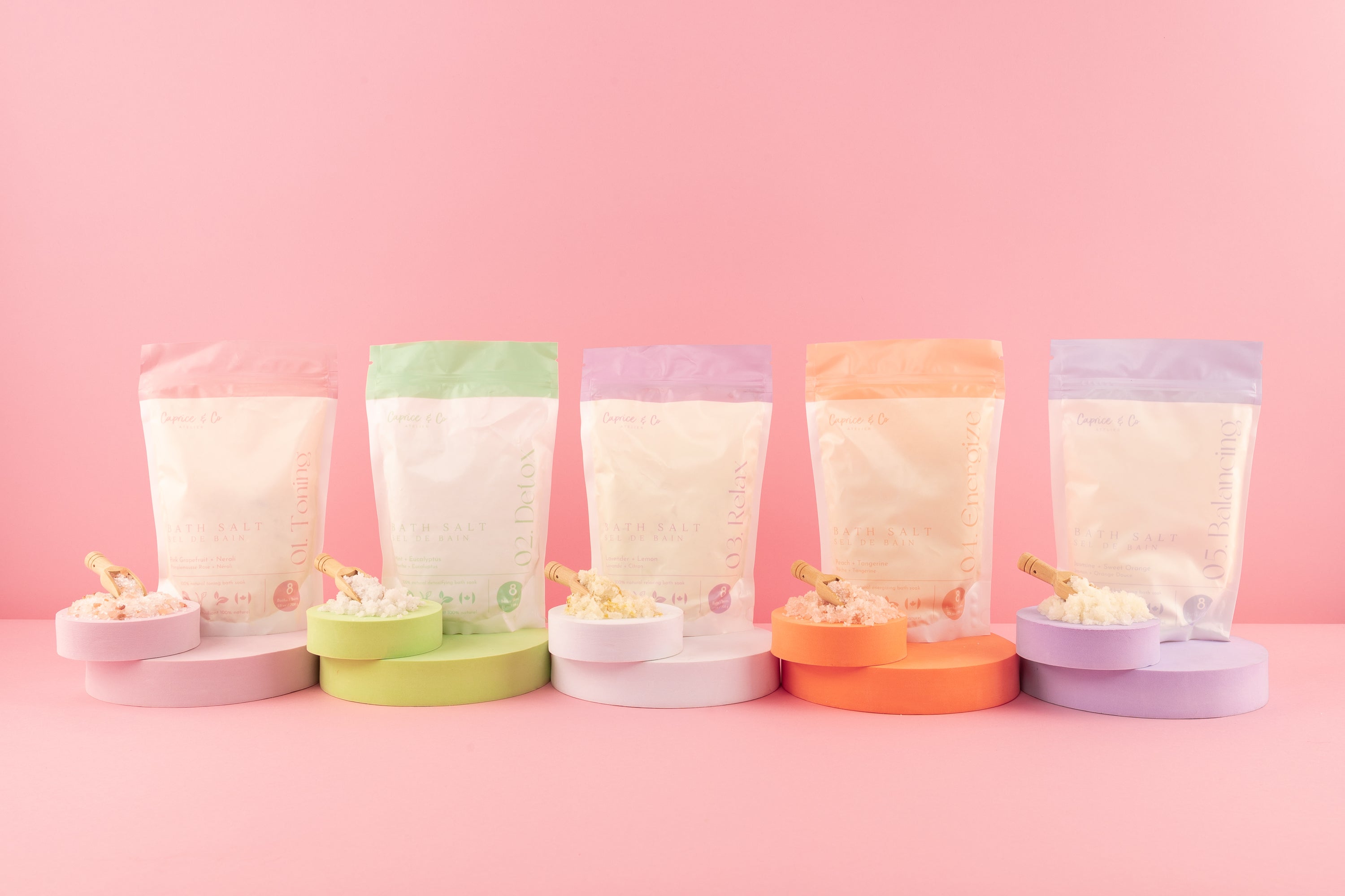 A collection of all-natural bath salts in various scents, showcasing colorful crystals and essential oils in elegant packaging.