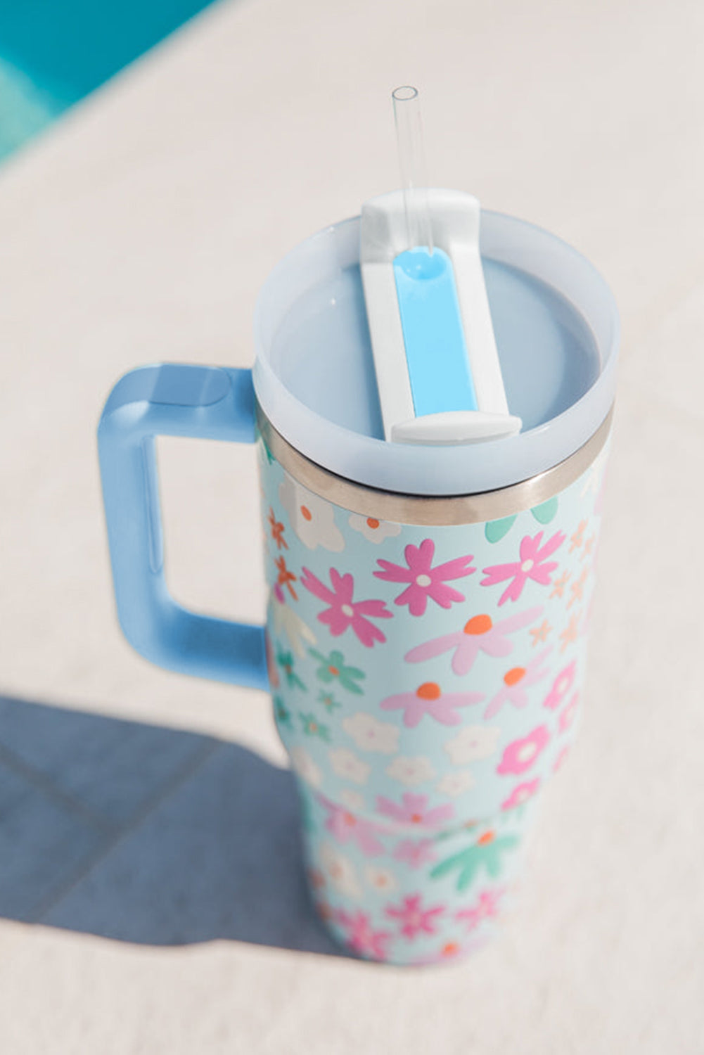 Beau Blue Cute Flower Pattern Handled Cup with Straw, featuring a vibrant floral design and a sturdy handle for easy carrying.