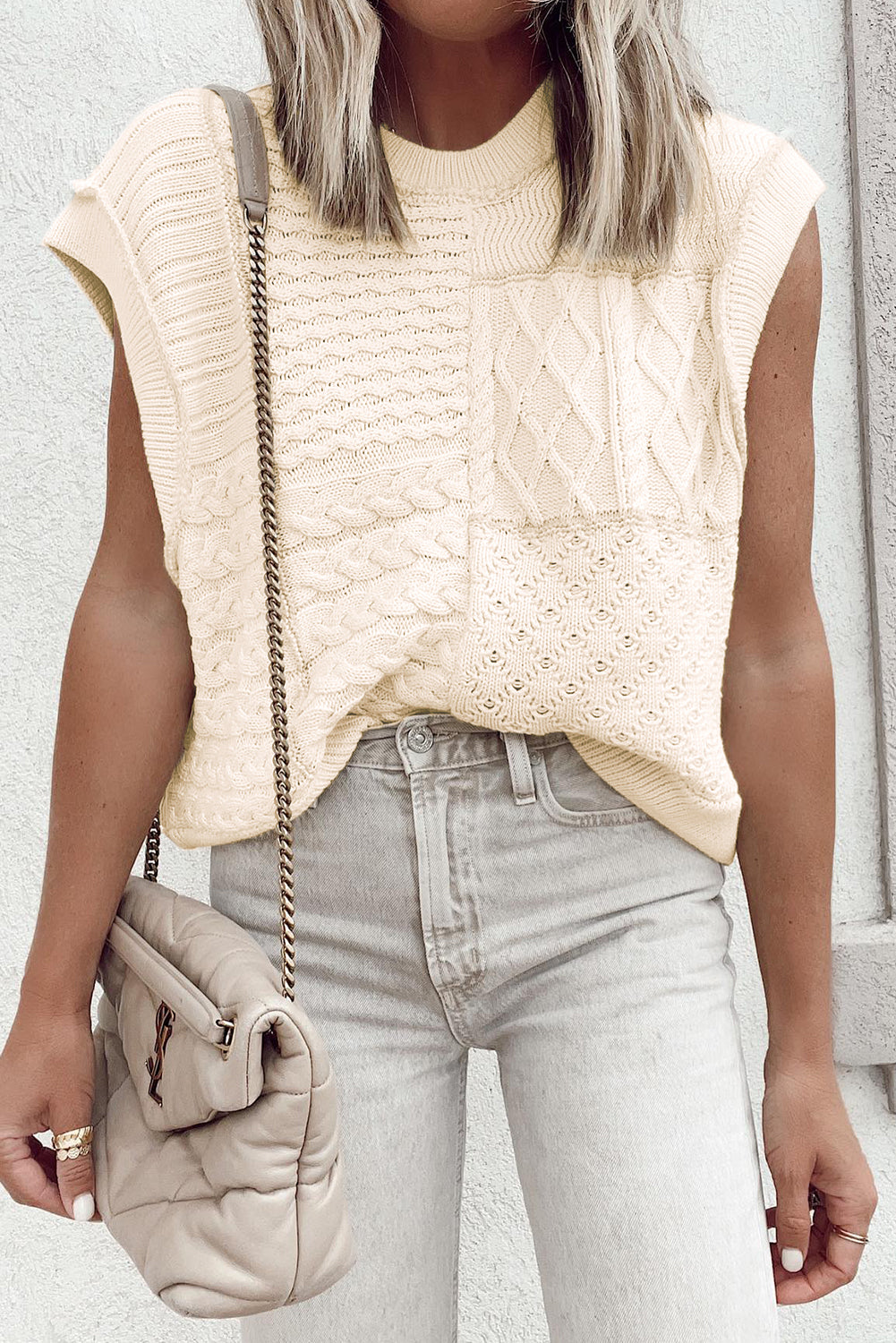 Beige cable knit sweater tank with dolman armholes, showcasing its soft texture and stylish design.