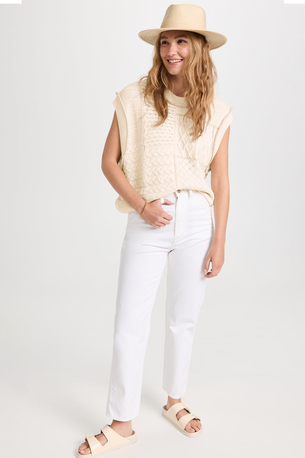 Beige cable knit sweater tank with dolman armholes, showcasing its soft texture and stylish design.