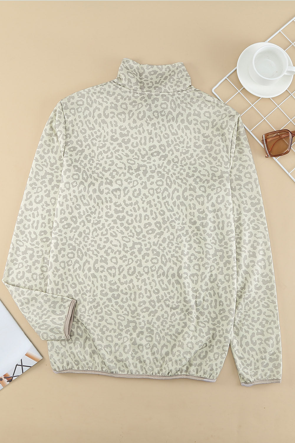 Beige lapel sweatshirt with leopard print, featuring a snap front and kangaroo pocket, perfect for casual wear.