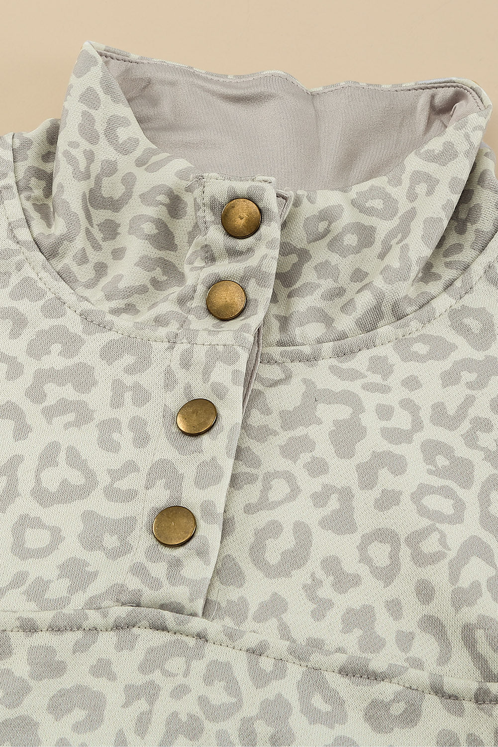 Beige lapel sweatshirt with leopard print, featuring a snap front and kangaroo pocket, perfect for casual wear.