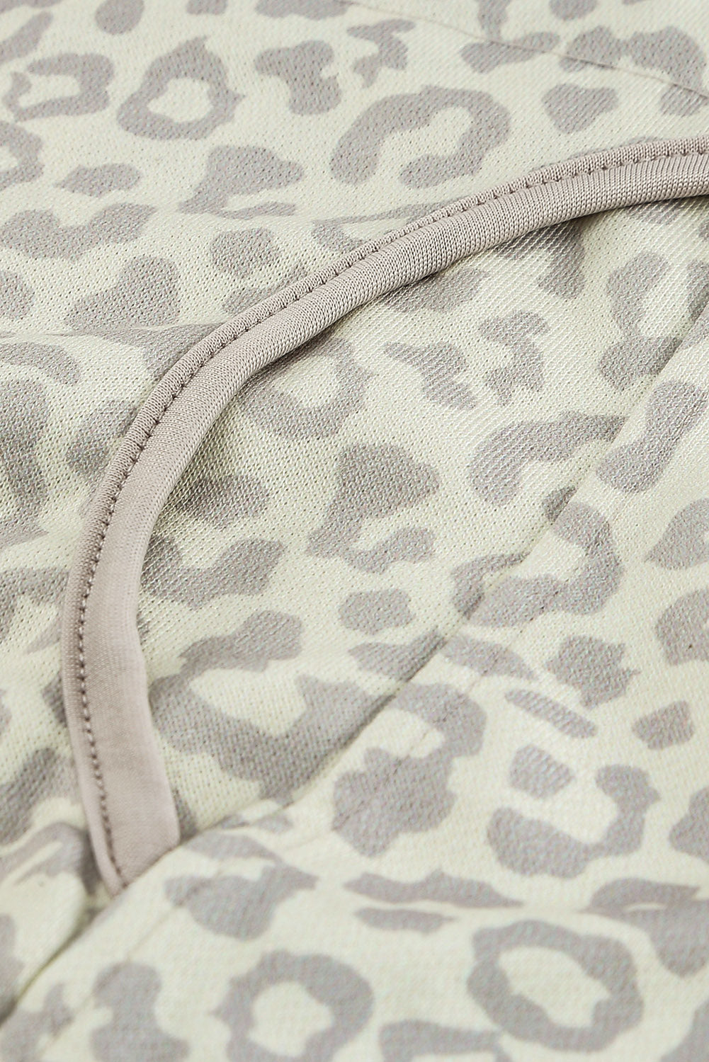 Beige lapel sweatshirt with leopard print, featuring a snap front and kangaroo pocket, perfect for casual wear.