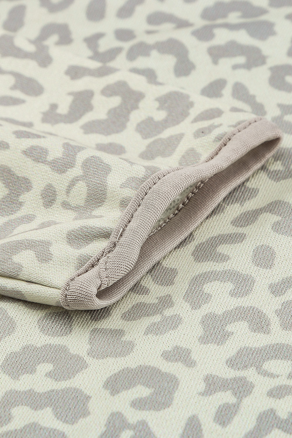 Beige lapel sweatshirt with leopard print, featuring a snap front and kangaroo pocket, perfect for casual wear.