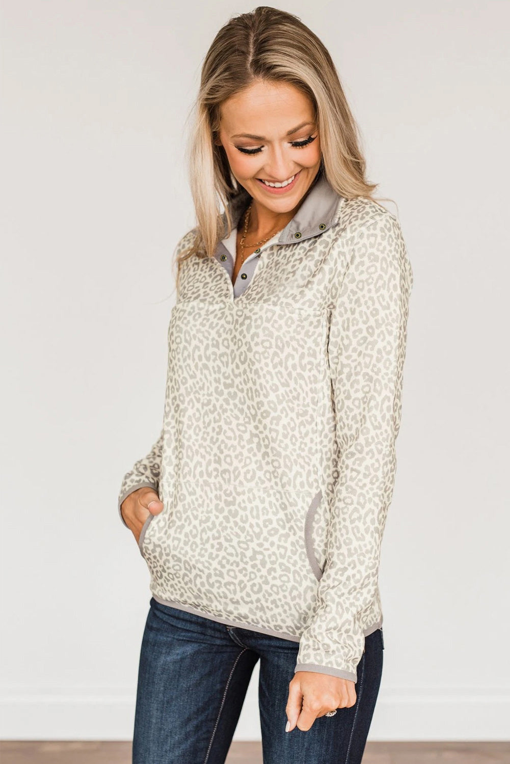 Beige lapel sweatshirt with leopard print, featuring a snap front and kangaroo pocket, perfect for casual wear.