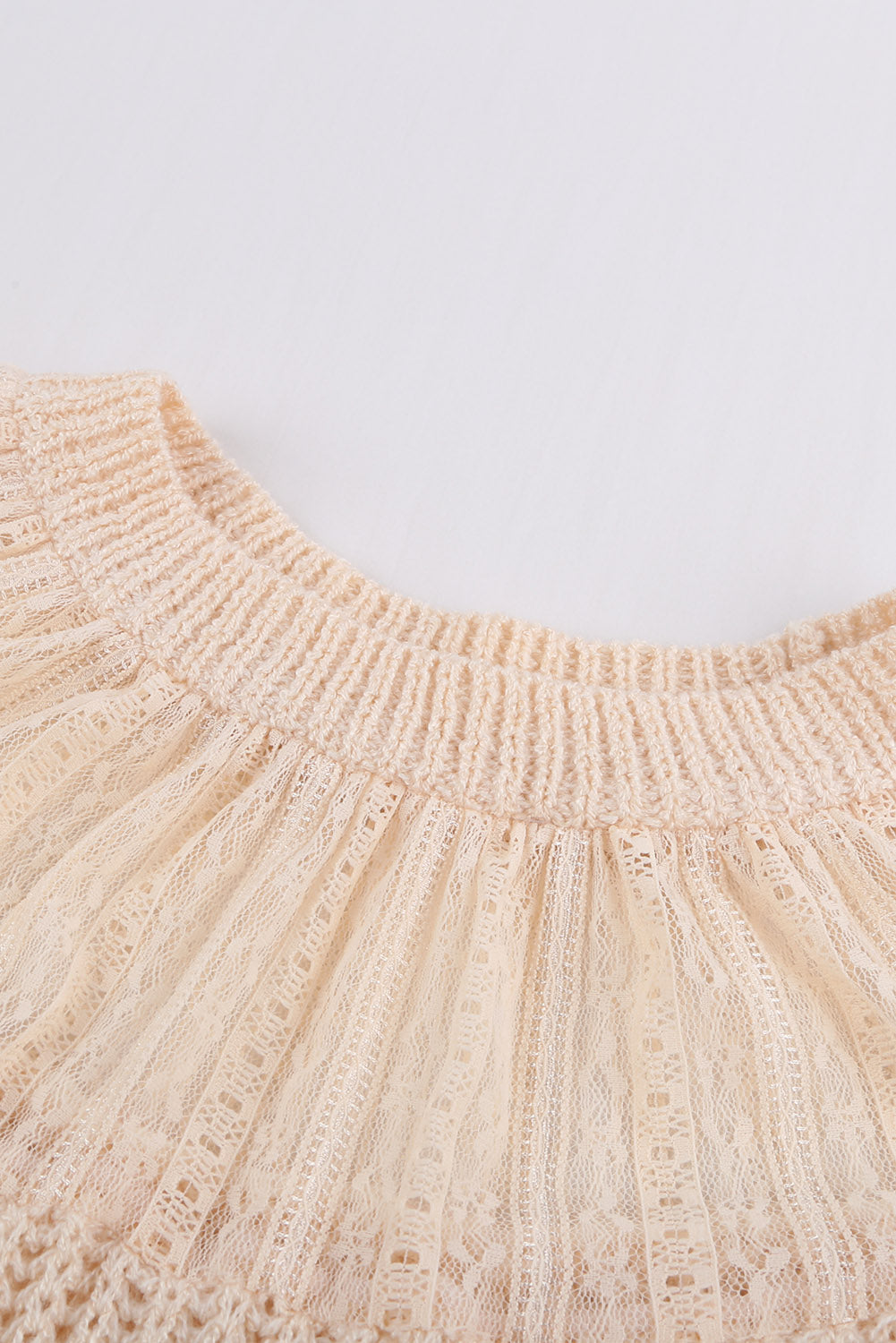 Beige knitted sweater featuring round neck and lace splicing details, perfect for stylish layering in chilly weather.