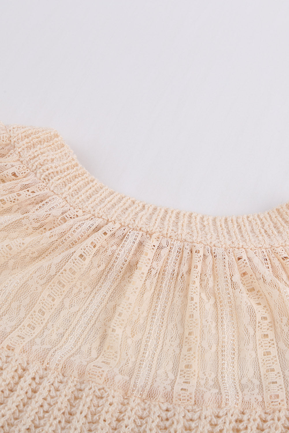 Beige knitted sweater featuring round neck and lace splicing details, perfect for stylish layering in chilly weather.