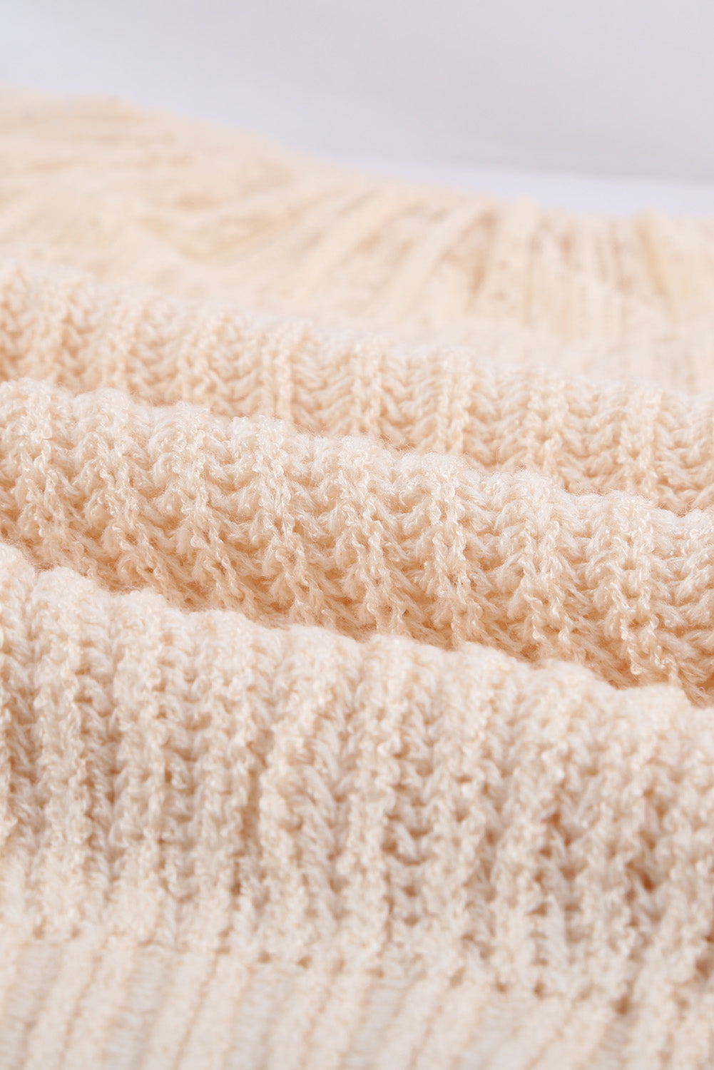 Beige knitted sweater featuring round neck and lace splicing details, perfect for stylish layering in chilly weather.