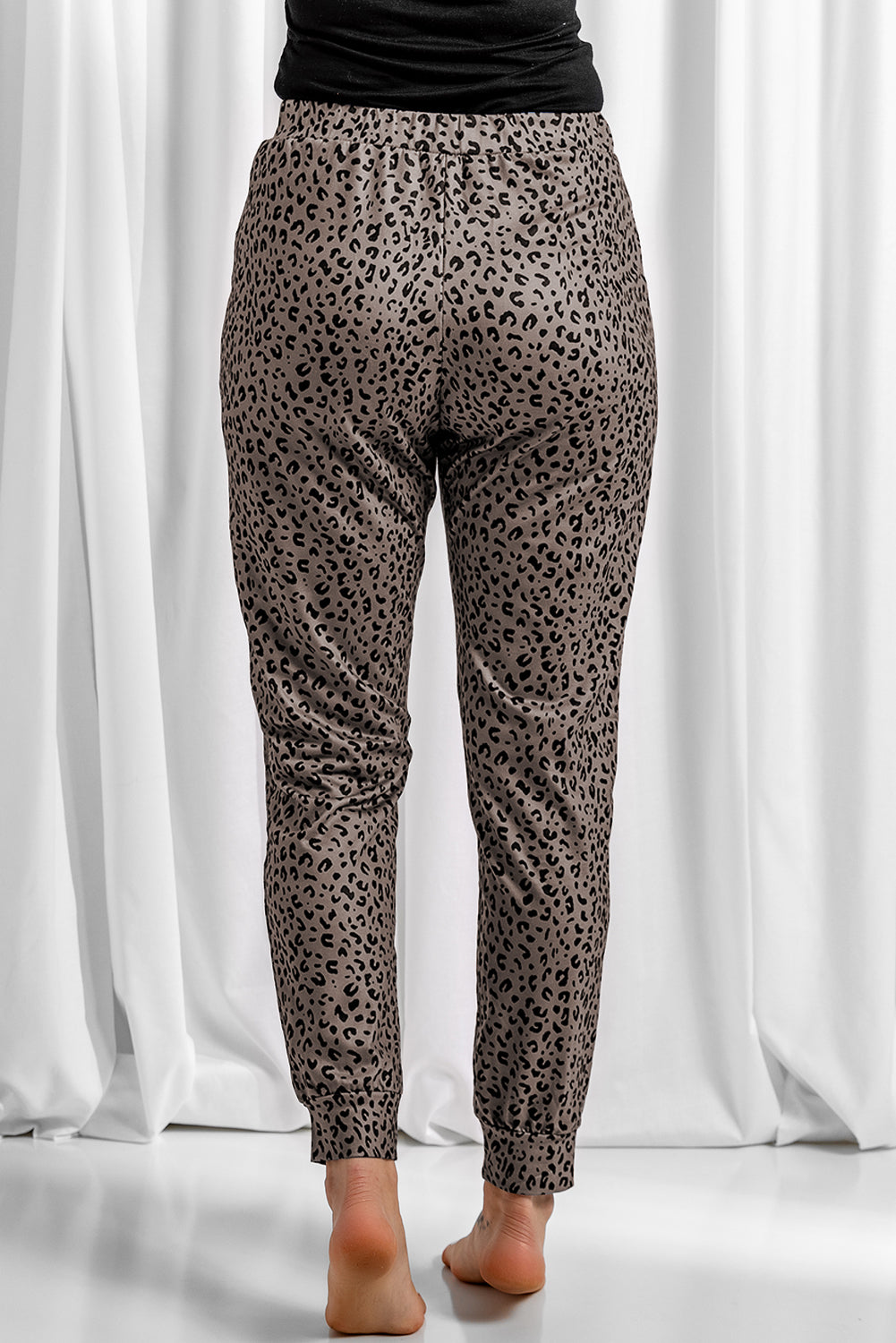 Black Breezy Leopard Joggers featuring a stylish leopard print and adjustable smocked waist, perfect for casual wear.