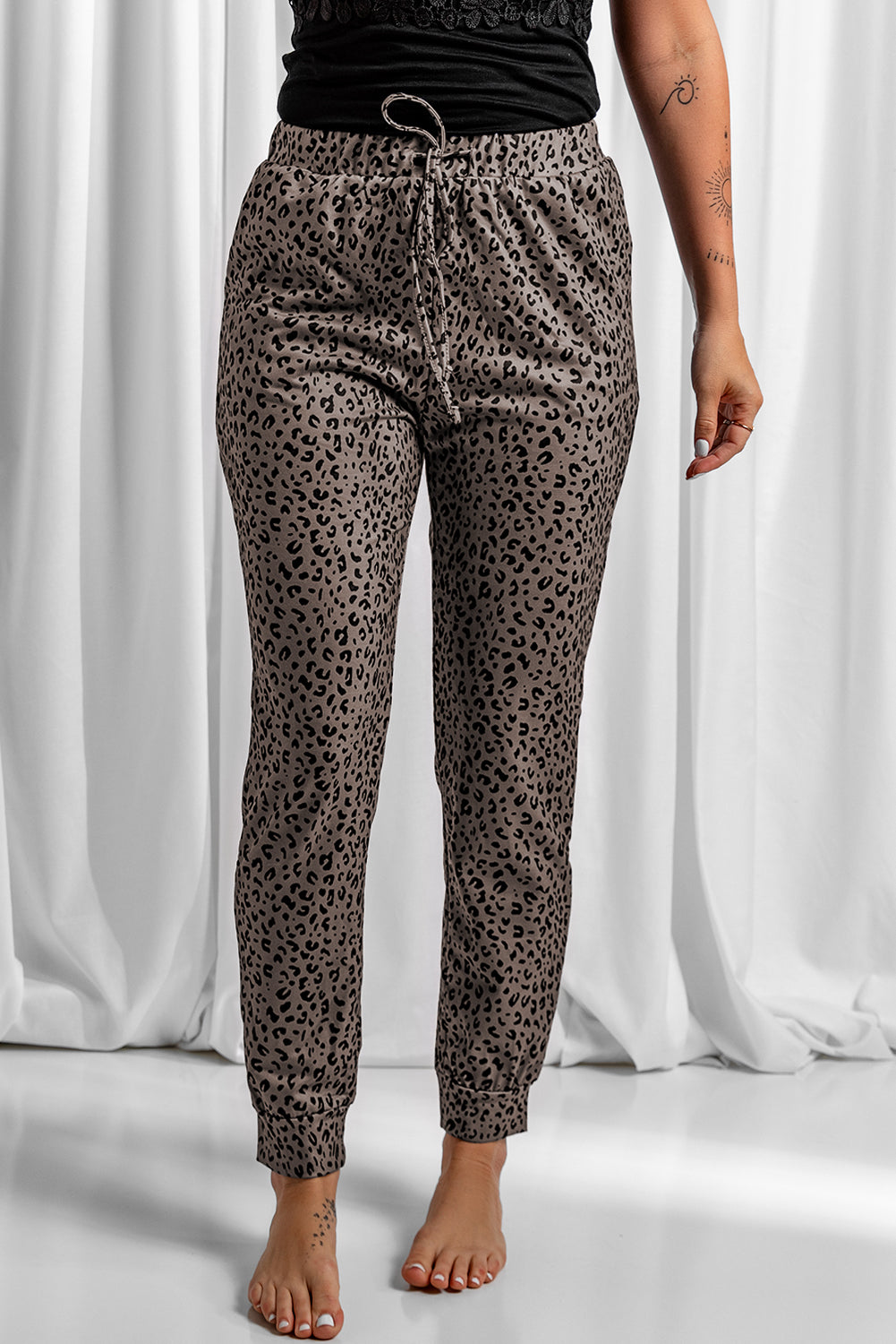 Black Breezy Leopard Joggers featuring a stylish leopard print and adjustable smocked waist, perfect for casual wear.