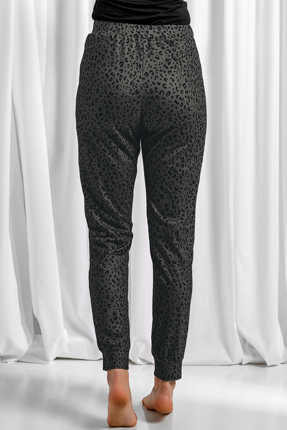 Black Breezy Leopard Joggers featuring a stylish leopard print and adjustable smocked waist, perfect for casual wear.