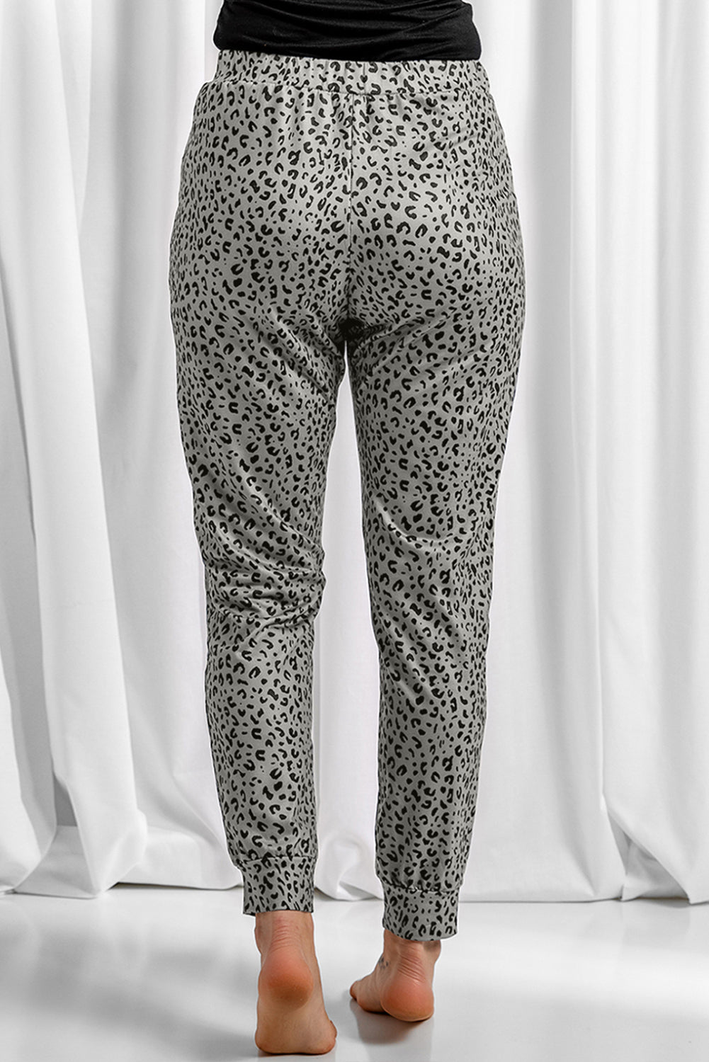 Black Breezy Leopard Joggers featuring a stylish leopard print and adjustable smocked waist, perfect for casual wear.