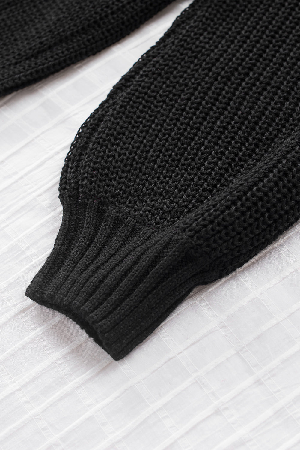 A stylish black casual loose halter neck sweater featuring cold shoulder cutouts and ribbed knit fabric, perfect for versatile styling.