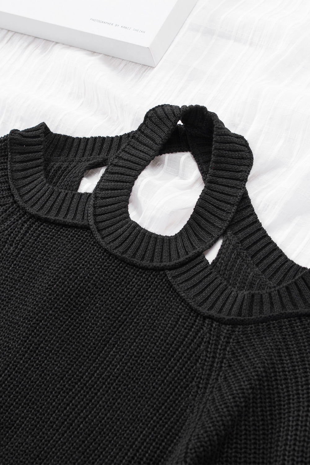 A stylish black casual loose halter neck sweater featuring cold shoulder cutouts and ribbed knit fabric, perfect for versatile styling.