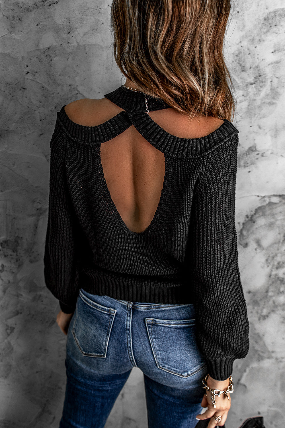 A stylish black casual loose halter neck sweater featuring cold shoulder cutouts and ribbed knit fabric, perfect for versatile styling.