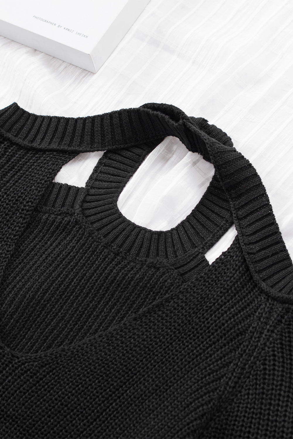 A stylish black casual loose halter neck sweater featuring cold shoulder cutouts and ribbed knit fabric, perfect for versatile styling.