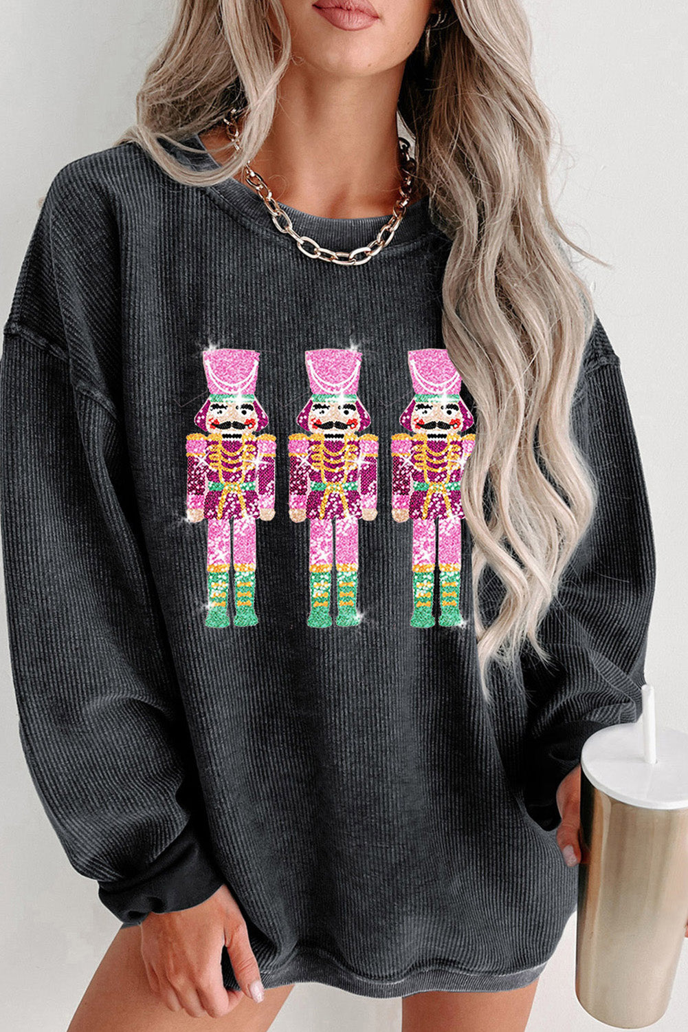 Black Christmas sweatshirt featuring sequined nutcracker design with a mineral wash finish, perfect for holiday celebrations.