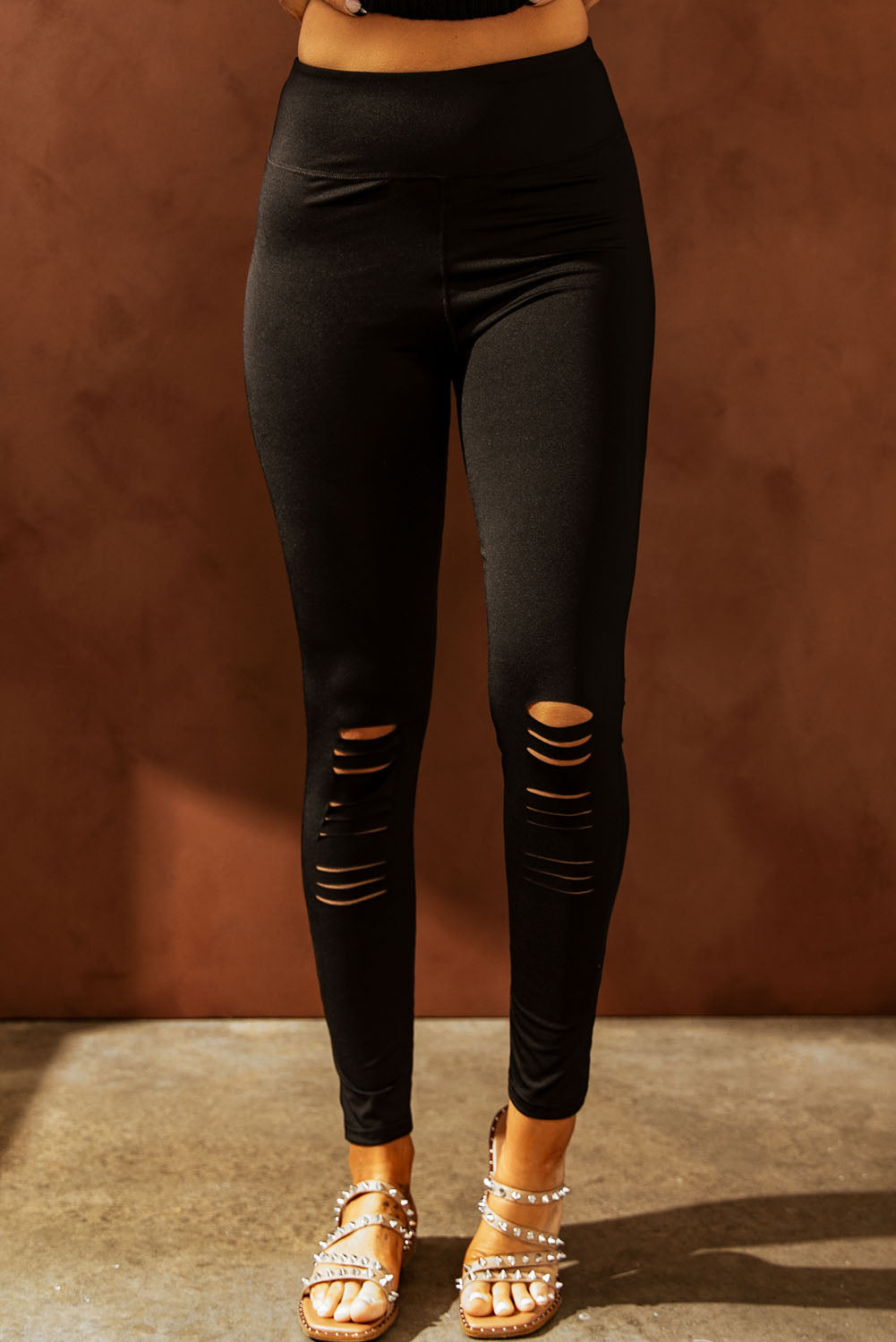 Black cut-out skinny high waist leggings showcasing a trendy design and high elastic material, perfect for stylish women.