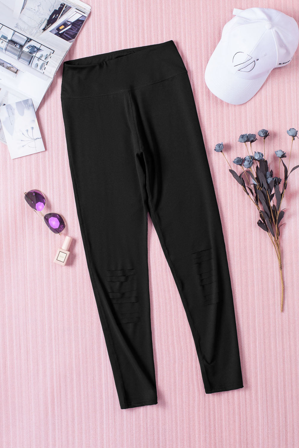 Black cut-out skinny high waist leggings showcasing a trendy design and high elastic material, perfect for stylish women.