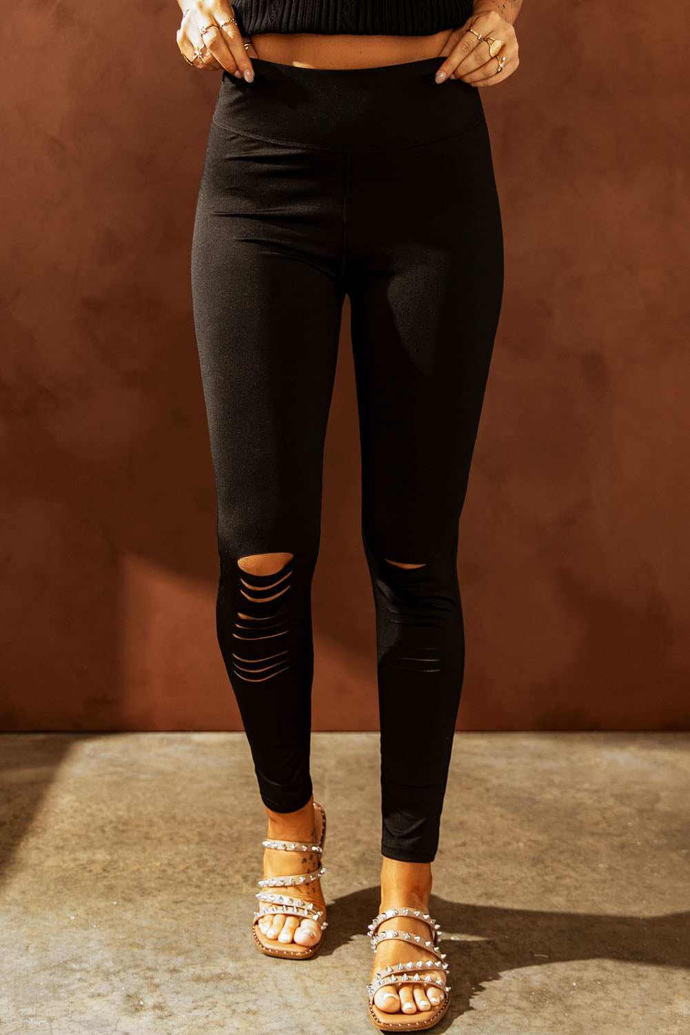 Black cut-out skinny high waist leggings showcasing a trendy design and high elastic material, perfect for stylish women.