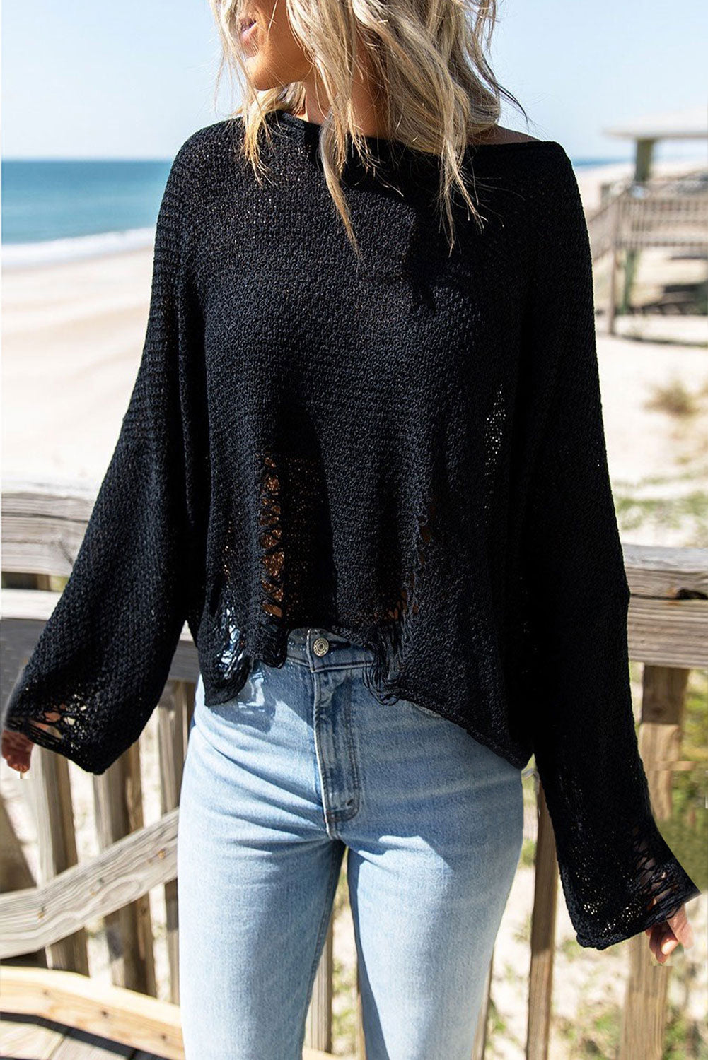 Black distressed boxy fit crop knit sweater with long sleeves, showcasing a relaxed style and trendy details.