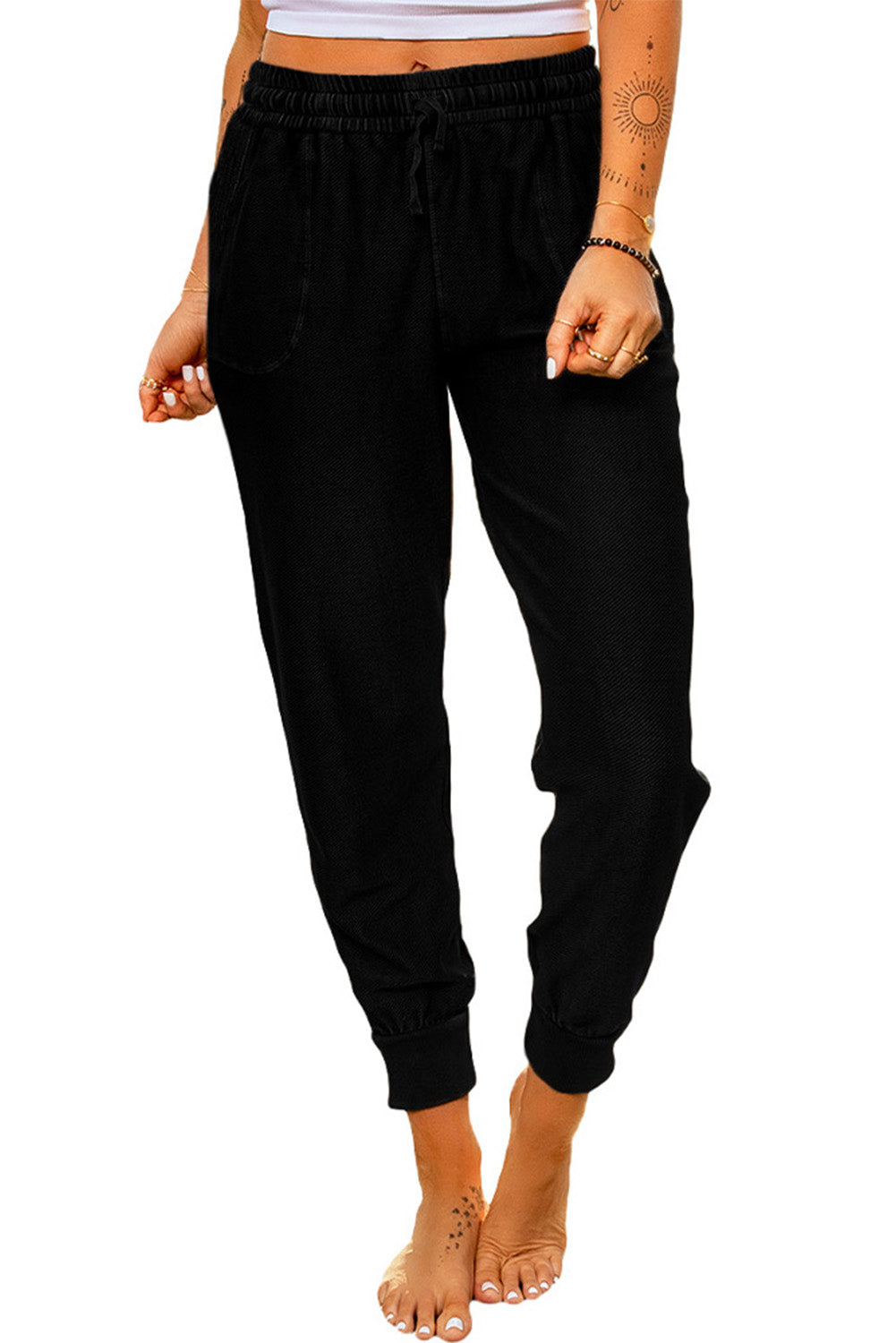 Black elastic waist jogger pants with side pockets, showcasing a relaxed fit and drawstring waist, perfect for casual wear.