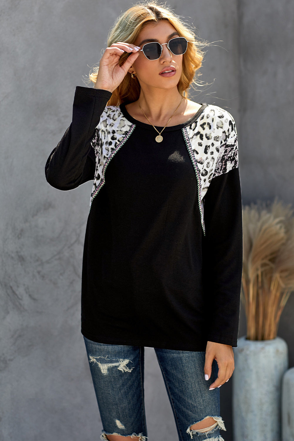 Black long sleeve top featuring a leopard snakeskin print, showcasing its stylish design and comfortable fabric.